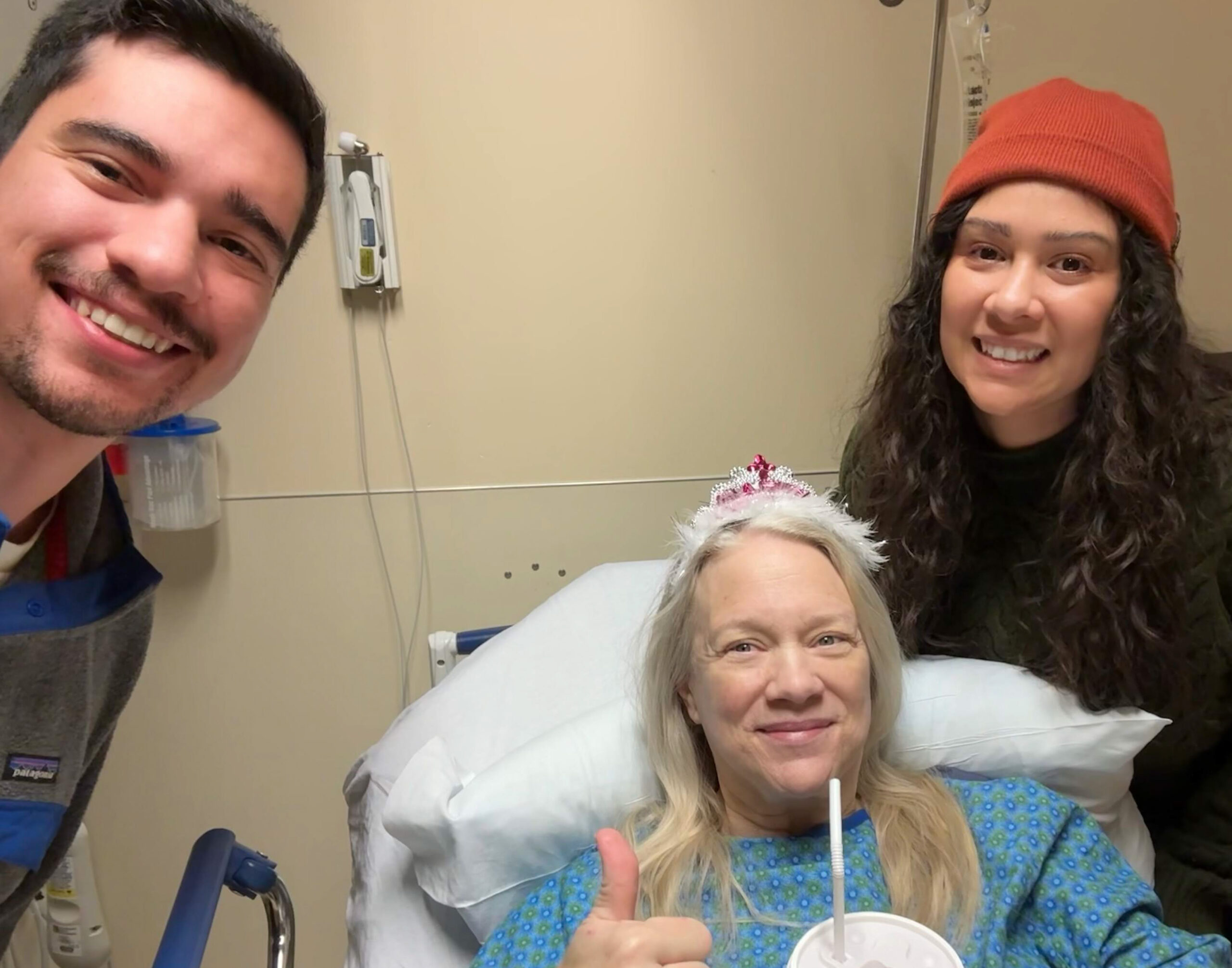 woman in hospital bed wearing tiara with son and daughter