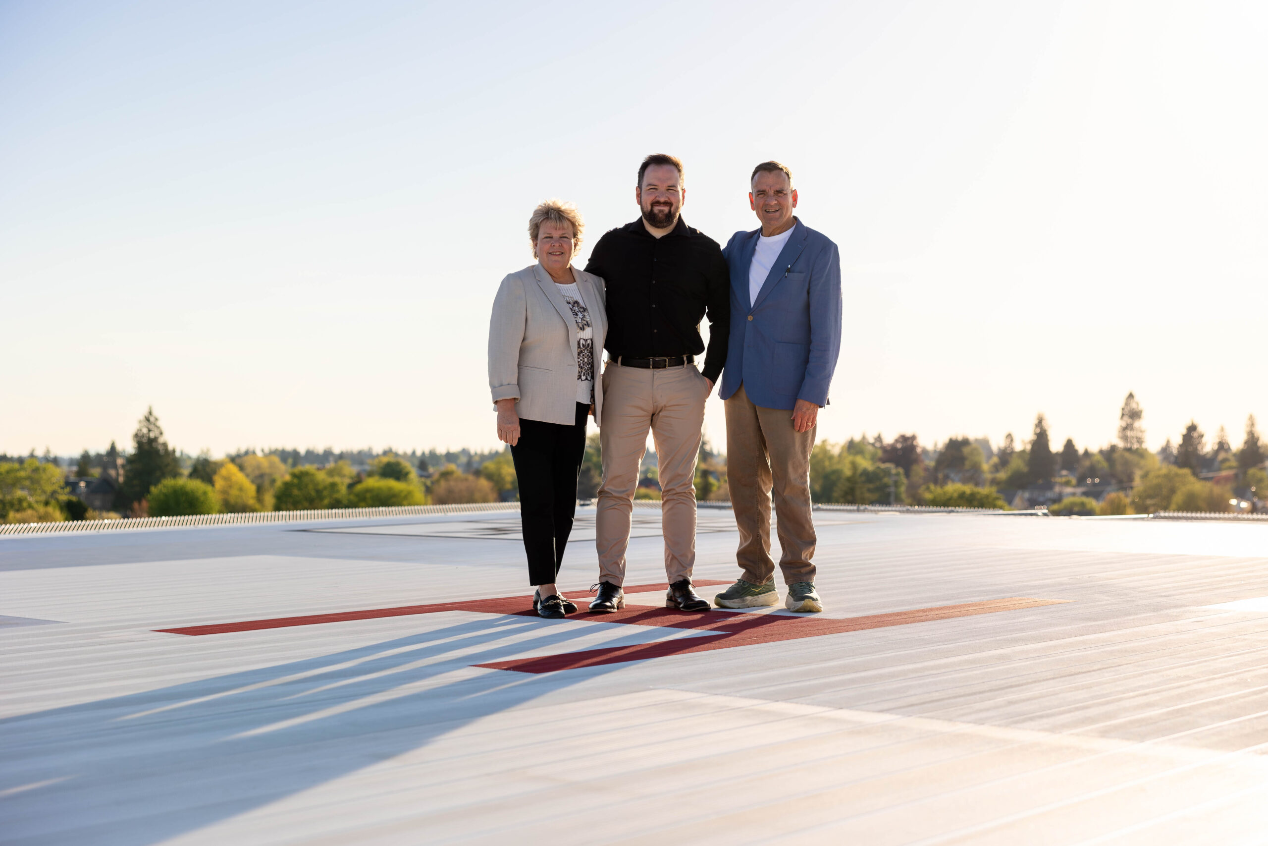 Three people standing on a rooftop helipad